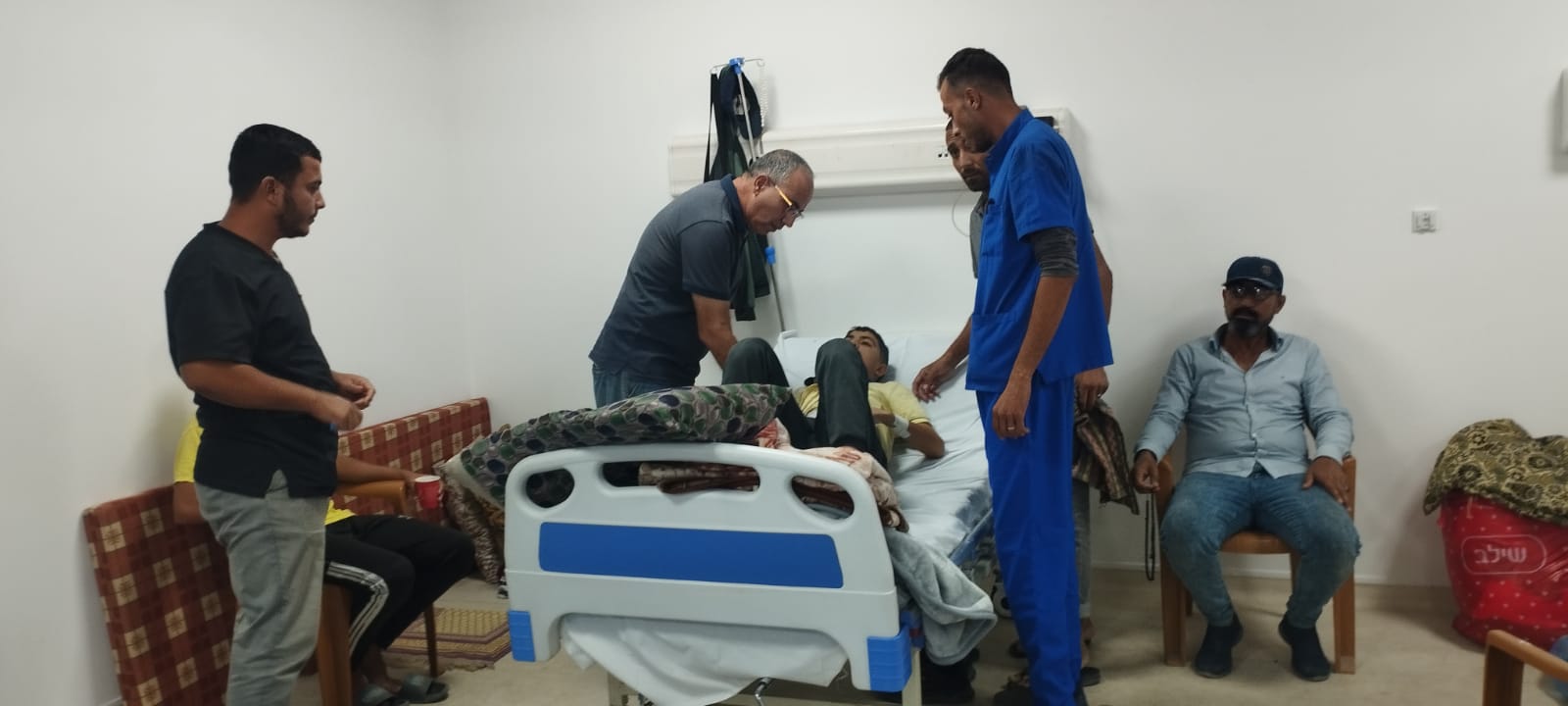 Doctors and family nearby a patient in Gaza cancer field hospital